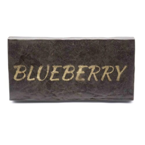 Brick of Blueberry Hash with a "Blueberry" gold stamp pressed into the surface, propped up on a clean white background