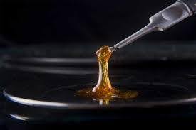 A close up image of cannabis honey oil dab with black background