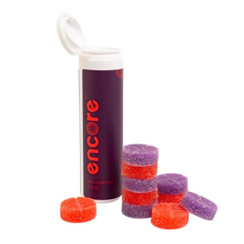 An image of Encore Edibles 600mg THC Wild Strawberry and Fruits Gummies in their tube packaging with some stacked in front of it to showcase the gummies