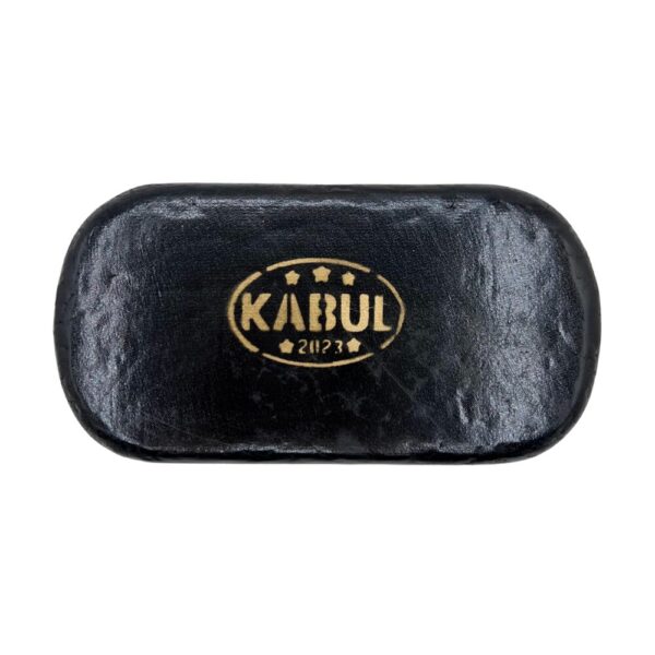 A round Afghan Kabul Hash brick with a gold embossed stamp on its dark surface, displayed on a white background.