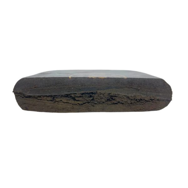 Close-up of a round Afghan Kabul Hash brick cut in half, revealing its dense, golden-brown interior against a white background