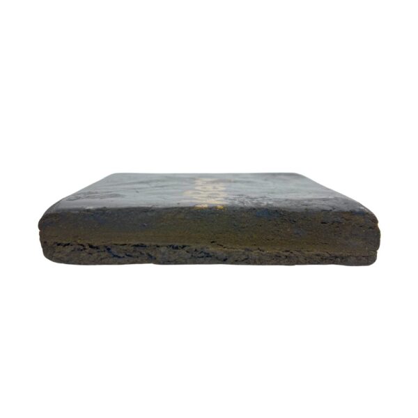 Blackberry Kush Hash brick sliced in half on a white background, displaying its rich, sticky interior and dense, chocolatey texture