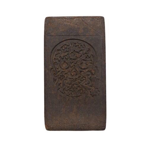 Beqaa Valley 1979 Hash slab photographed against a clean white background. The dark brown rectangular hash block features an intricate embossed skull design